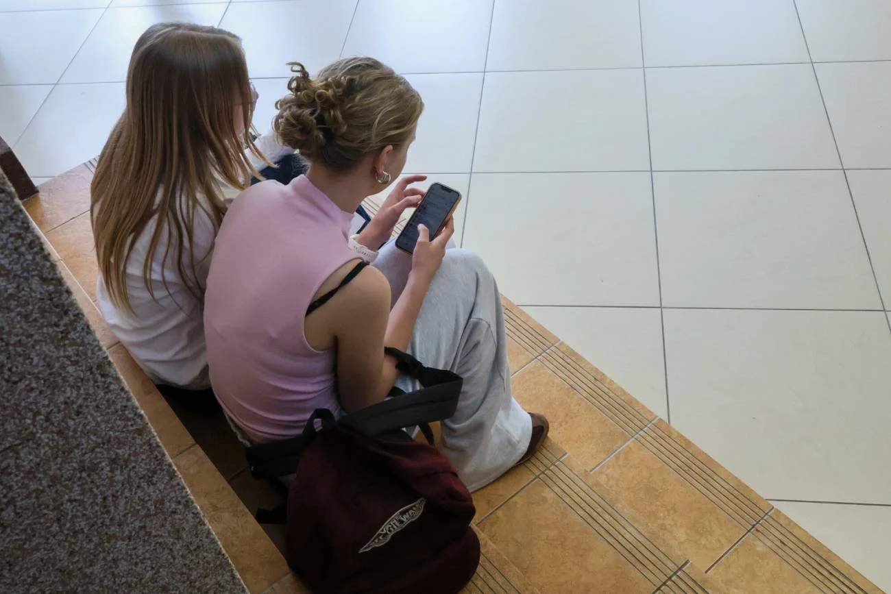 Uczennice na korytarzu ze smartfonami. Uczennice na korytarzu ze smartfonami.