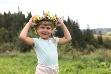 Uśmiechnięta dziewczynka w wianku z polnych kwiatów. Uśmiechnięta dziewczynka w wianku z polnych kwiatów.