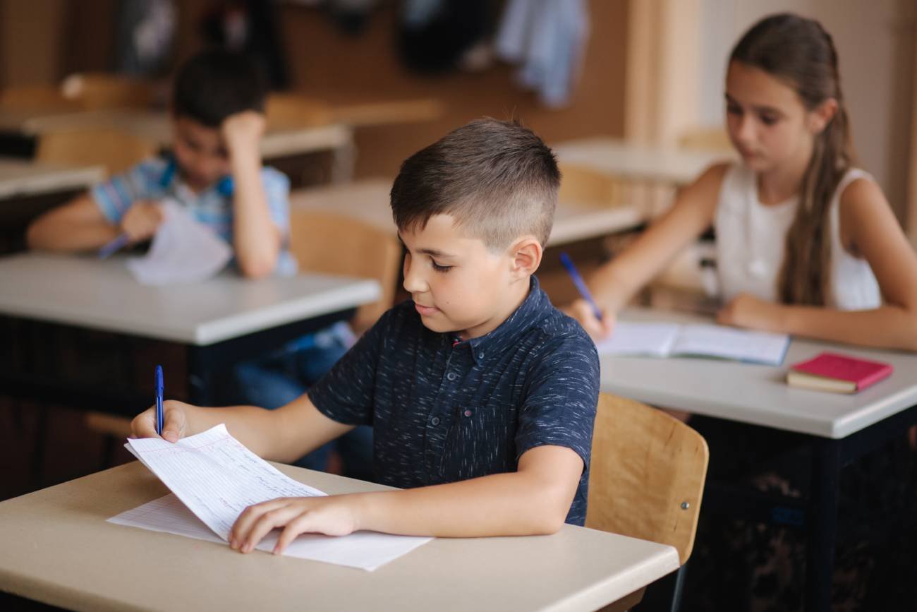 Uczniowie w ławkach na lekcji.