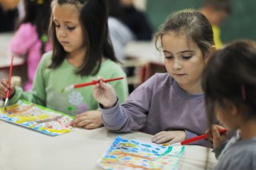 Dzieci malują obrazki na zajęciach z religii w przedszkolu.