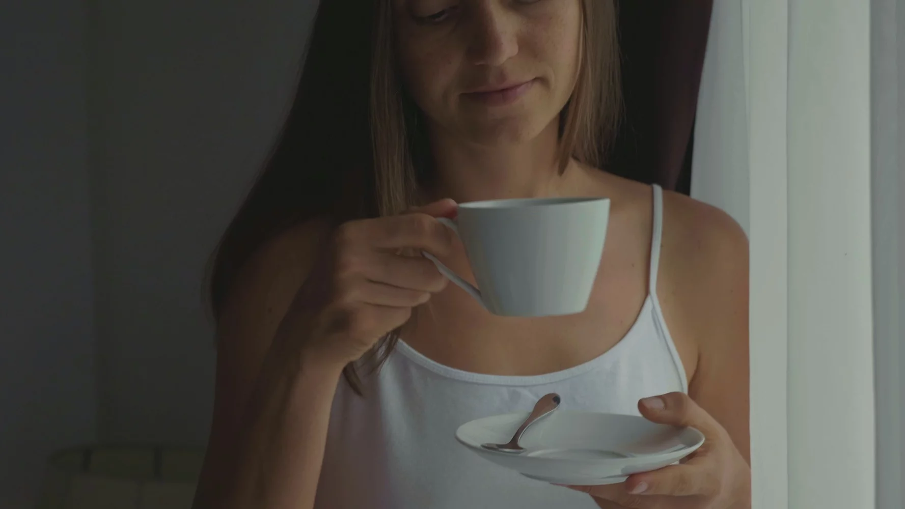 Młoda mama pije kawę w domu.