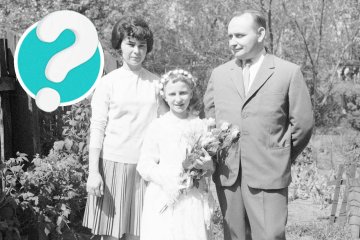 Dziewczynka po Pierwszej Komunii Świętej w PRL-u pozuje z rodzicami.