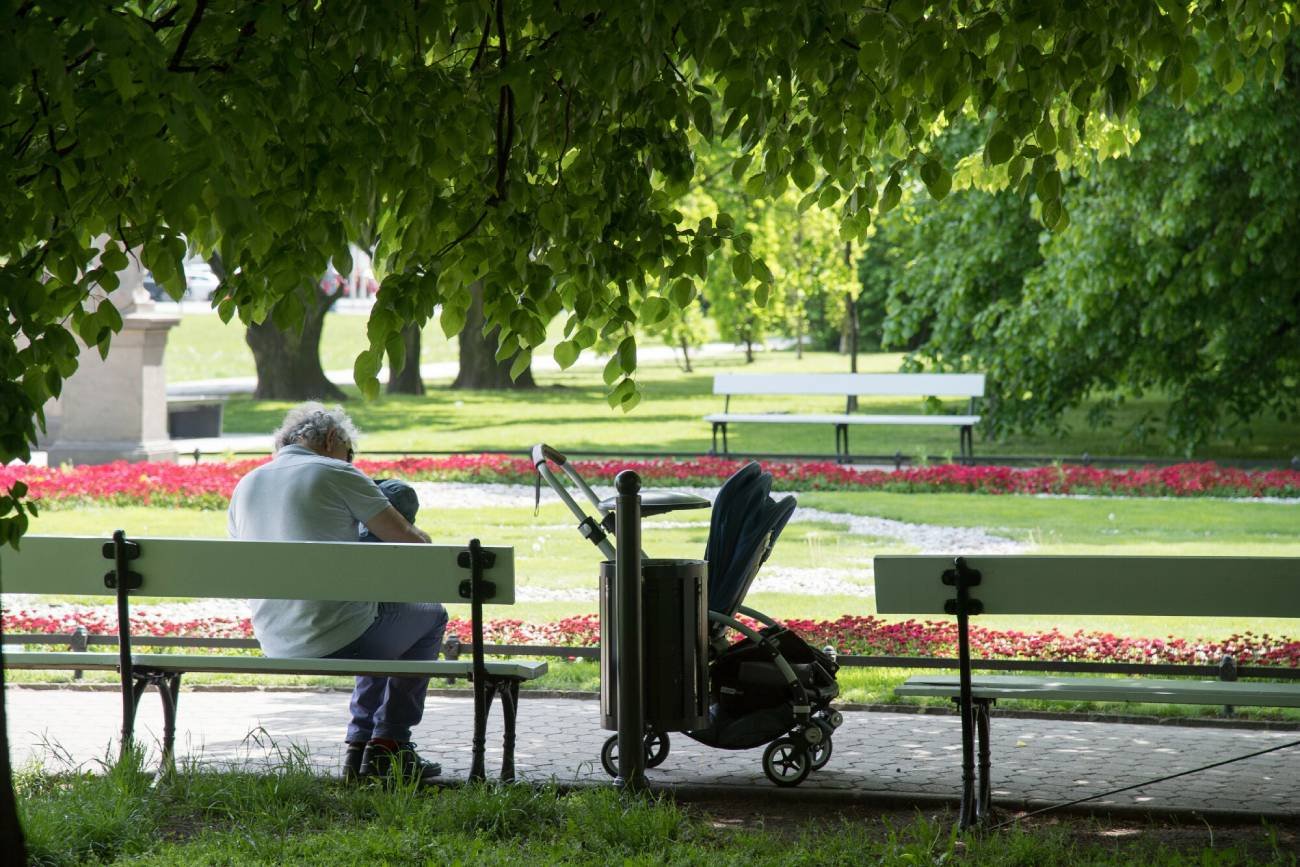 Babcia opiekująca się wnuczkiem na ławce w parku.