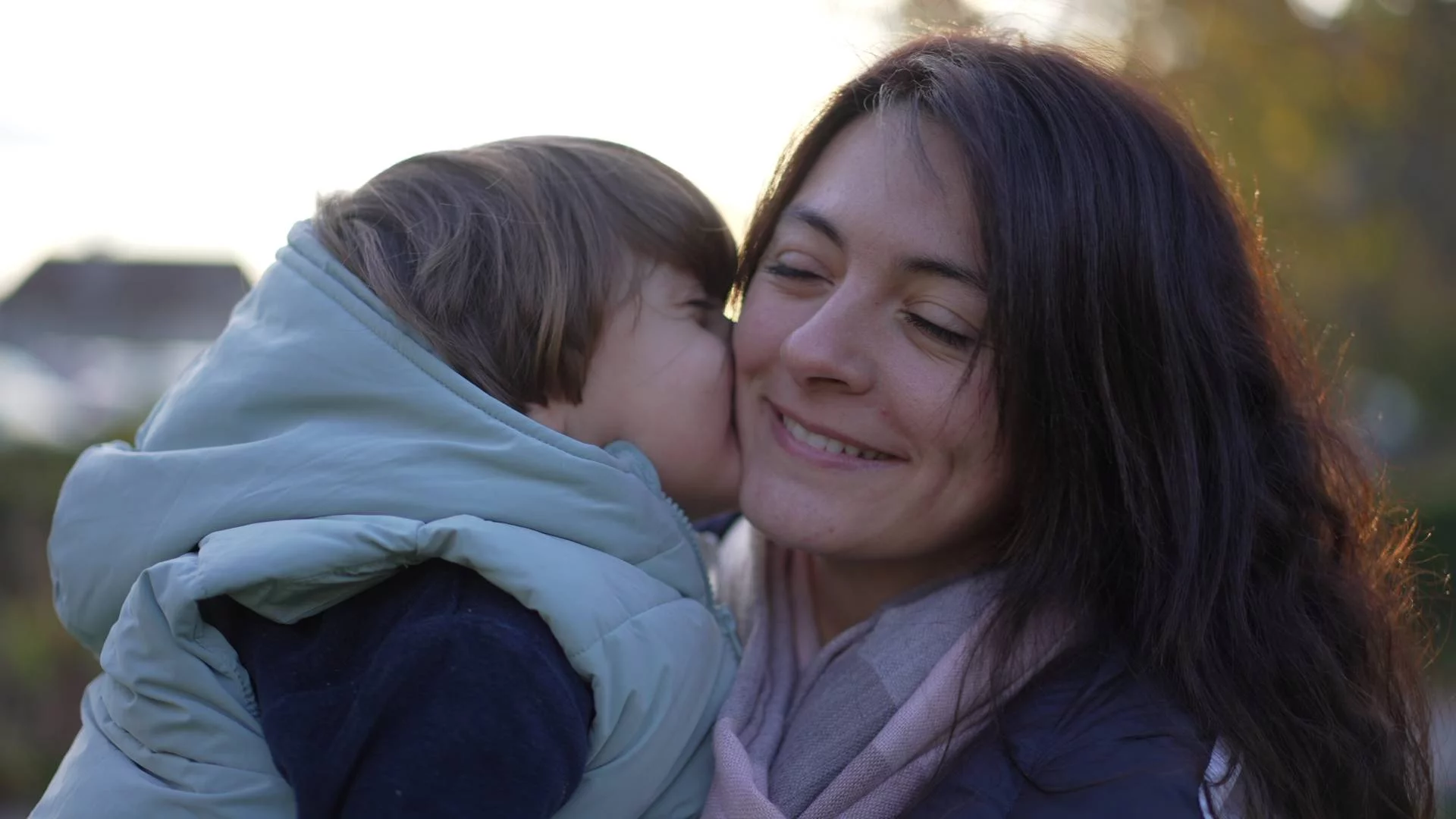 dziecko całuje mamę w policzek i się przytulają dziecko całuje mamę w policzek i się przytulają