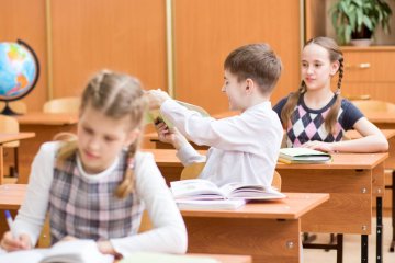 Uczniowie podczas lekcji siedzą w ławkach. Uczniowie podczas lekcji siedzą w ławkach.