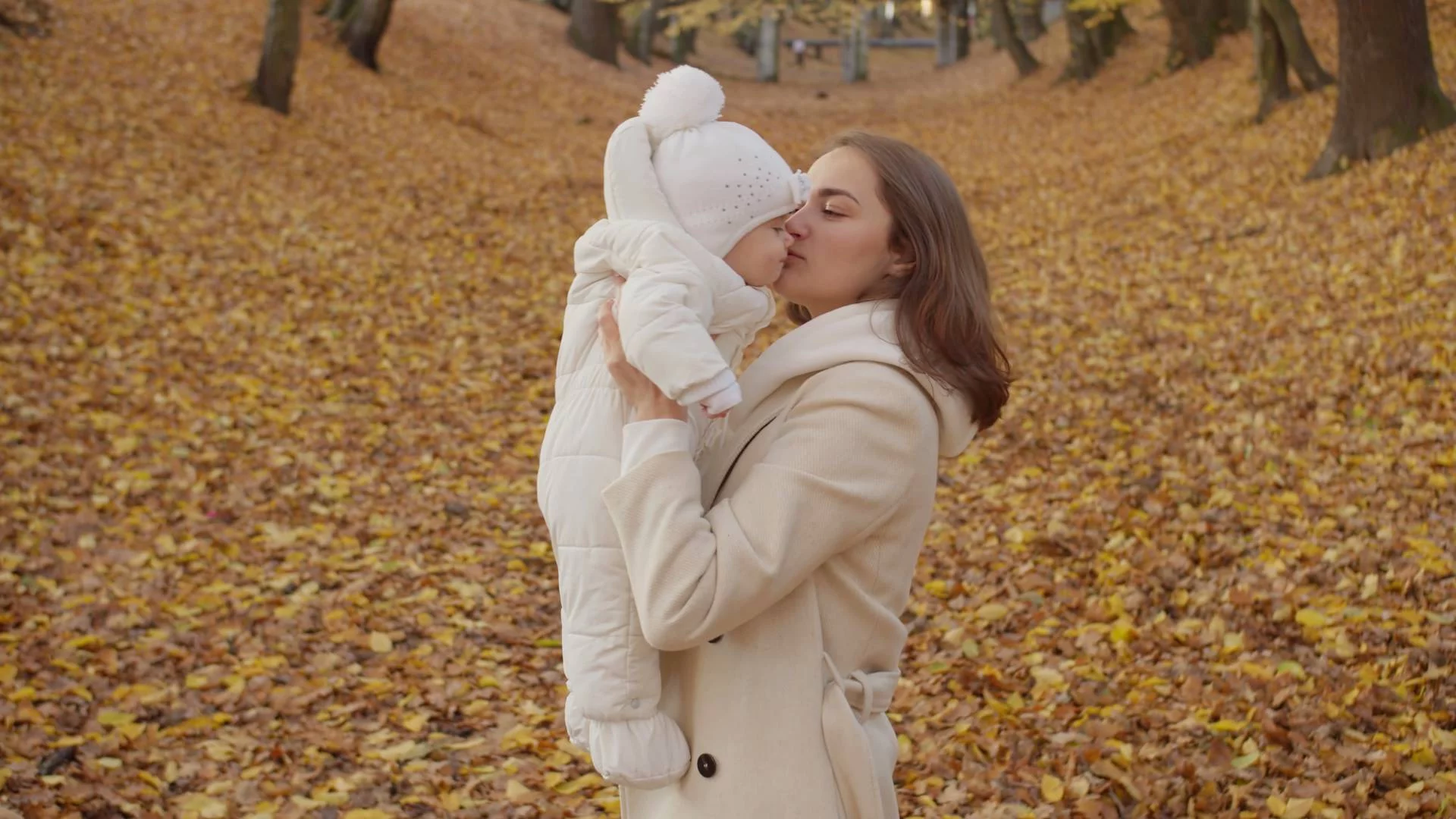 młoda mama z pokolenia Z z niemowlakiem na jesiennym spacerze w parku