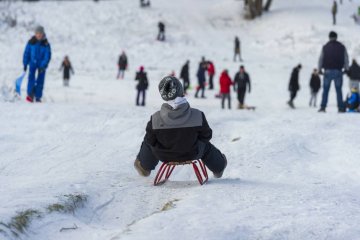 Dzieci podczas ferii jeżdżą na sankach.