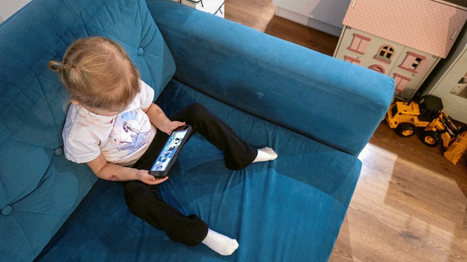 Małe dziecko patrzy w ekran smartfona.