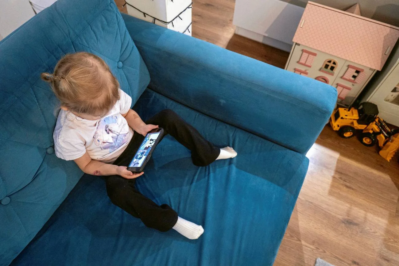 Małe dziecko patrzy w ekran smartfona. Małe dziecko patrzy w ekran smartfona.