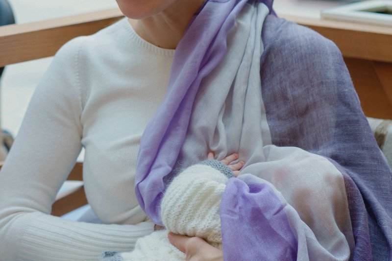 Wiele kobiet na czas karmienia piersią przykrywa dziecku głowę