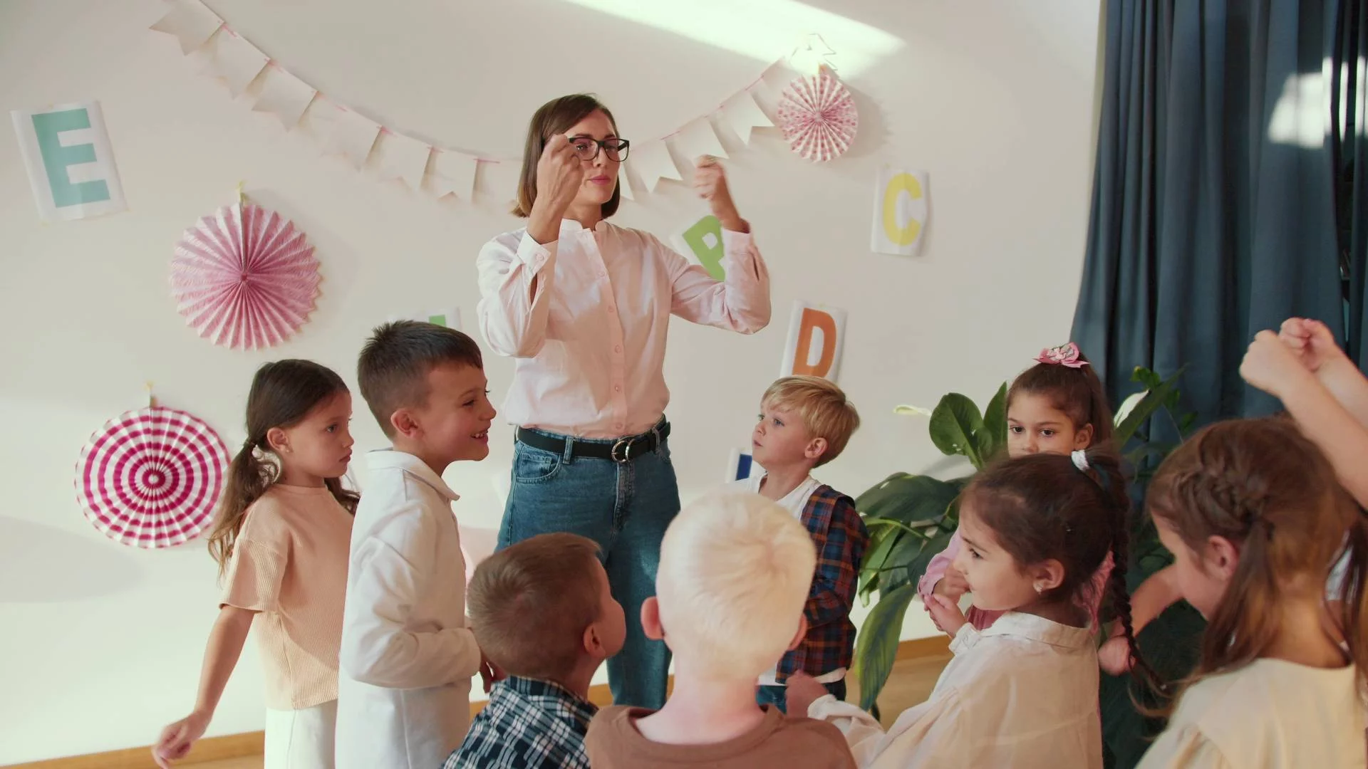 nauczycielka w przedszkolu z dziećmi bawi się i śpiewa nauczycielka w przedszkolu z dziećmi bawi się i śpiewa