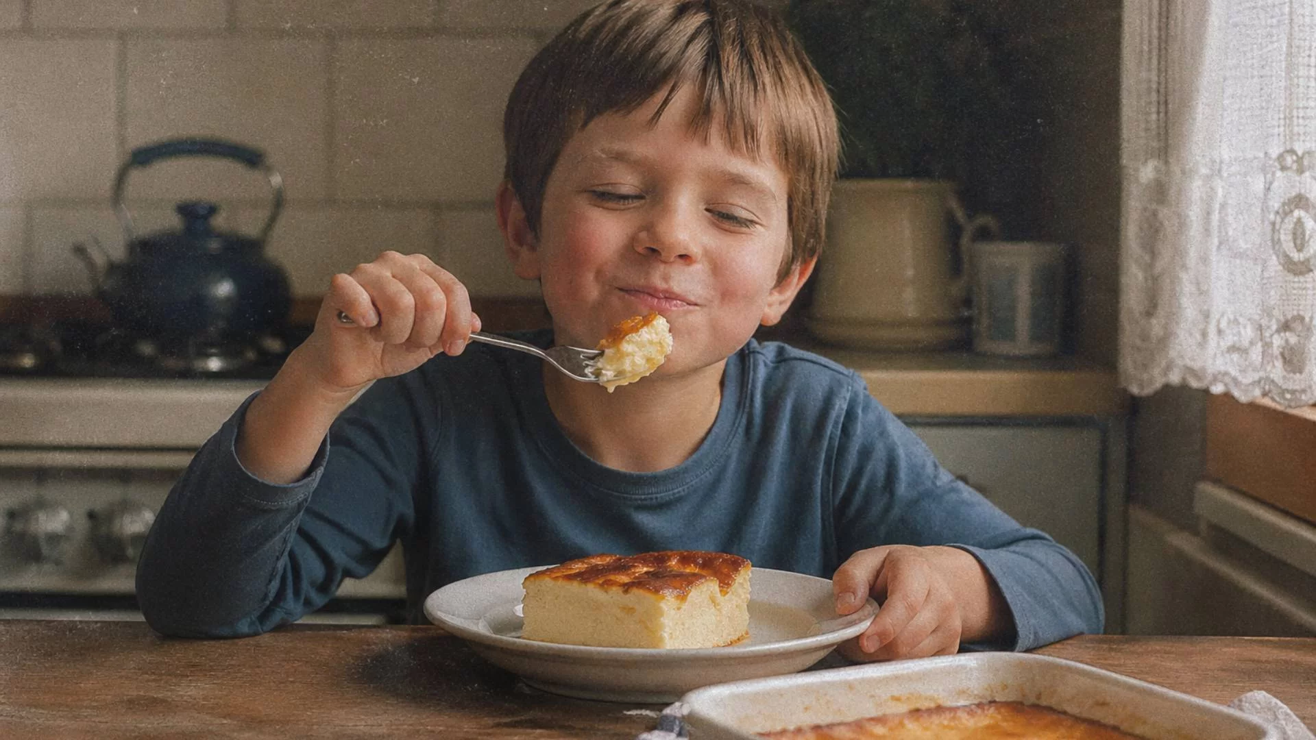 chłopiec w kuchni przy stole je pieczone mleko