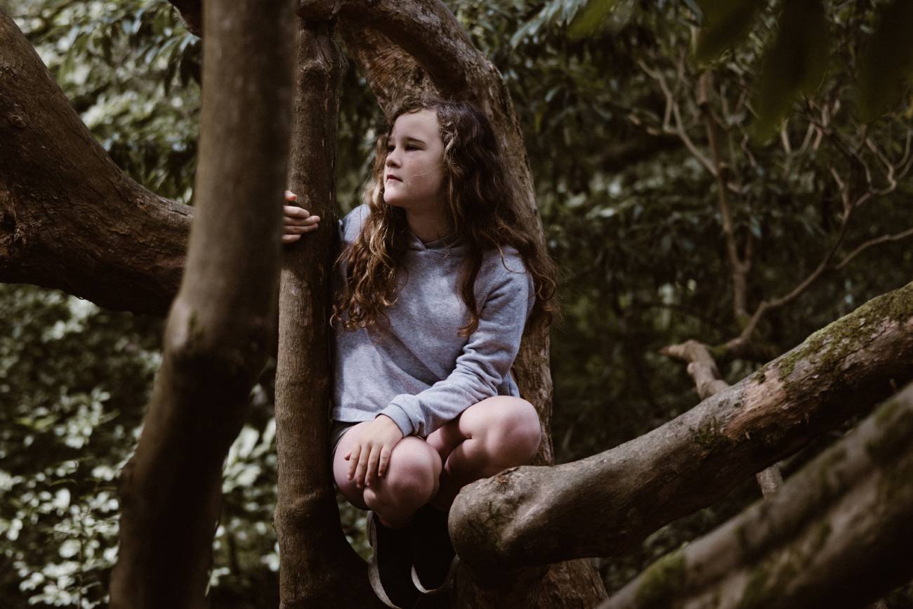 Dziewczynka siedzi na drzewie