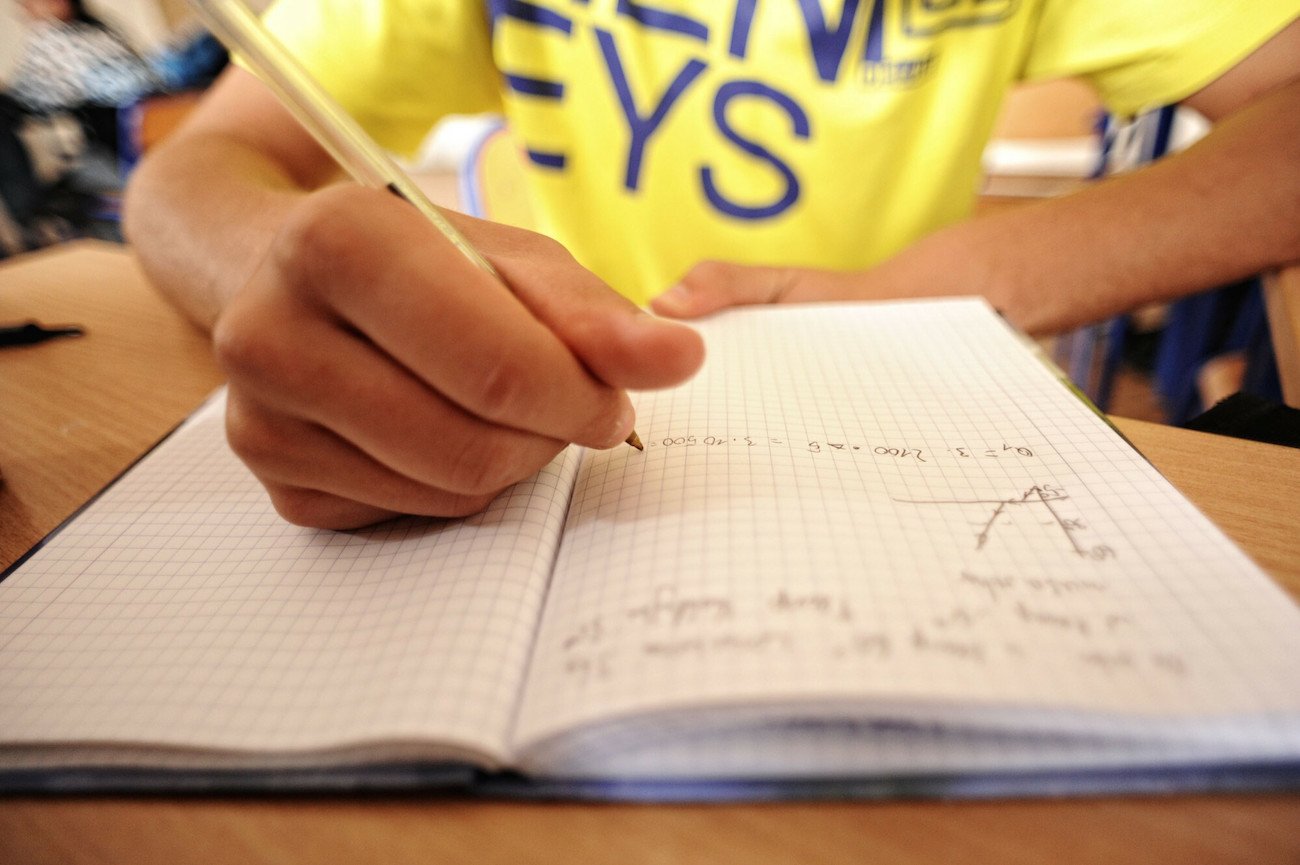 chłopiec pisze w zeszycie