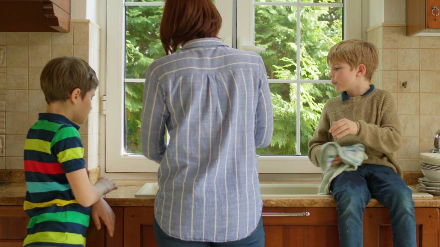 mama z dwoma synami sprząta w kuchni mama z dwoma synami sprząta w kuchni