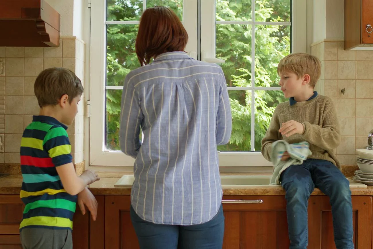 mama z dwoma synami sprząta w kuchni