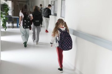 Uczniowie idą szkolnym korytarzem. Uczniowie idą szkolnym korytarzem.