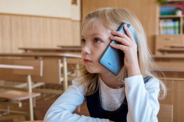 dziecko z telefonem w szkole
