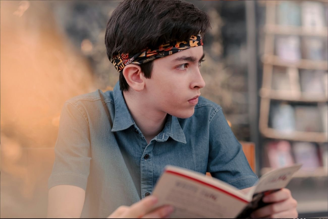 Maturzysta czyta lekturę do matury 2025.