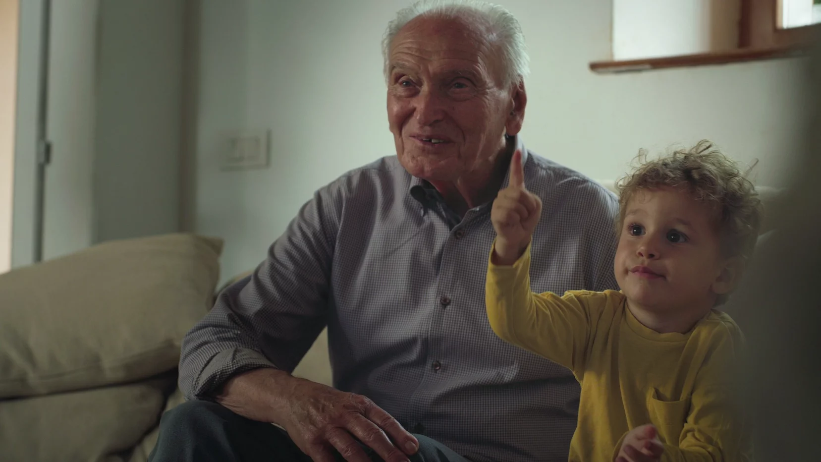 Rodziny wielopokoleniowe to przeszłość. Na zdjęciu mały chłopiec siedzi ze starszym mężczyzną (pradziadkiem)