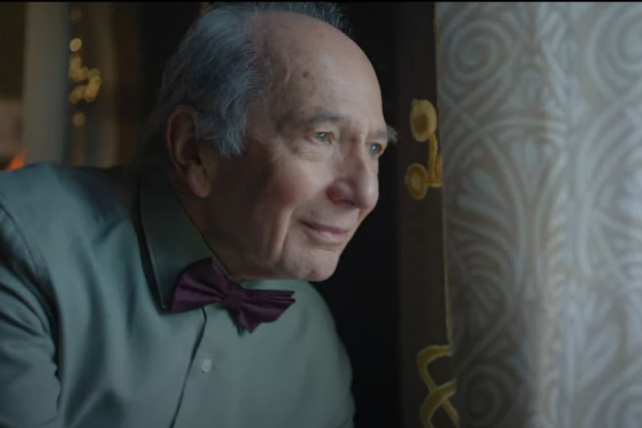Dziadek, bohater świątecznej reklamy Allegro, wygląda przez okno.