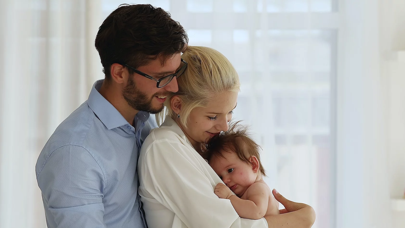Każda mama powinna usłyszeć te słowa. Na zdjęciu mężczyzna obejmuje partnerkę trzymającą dziecko.