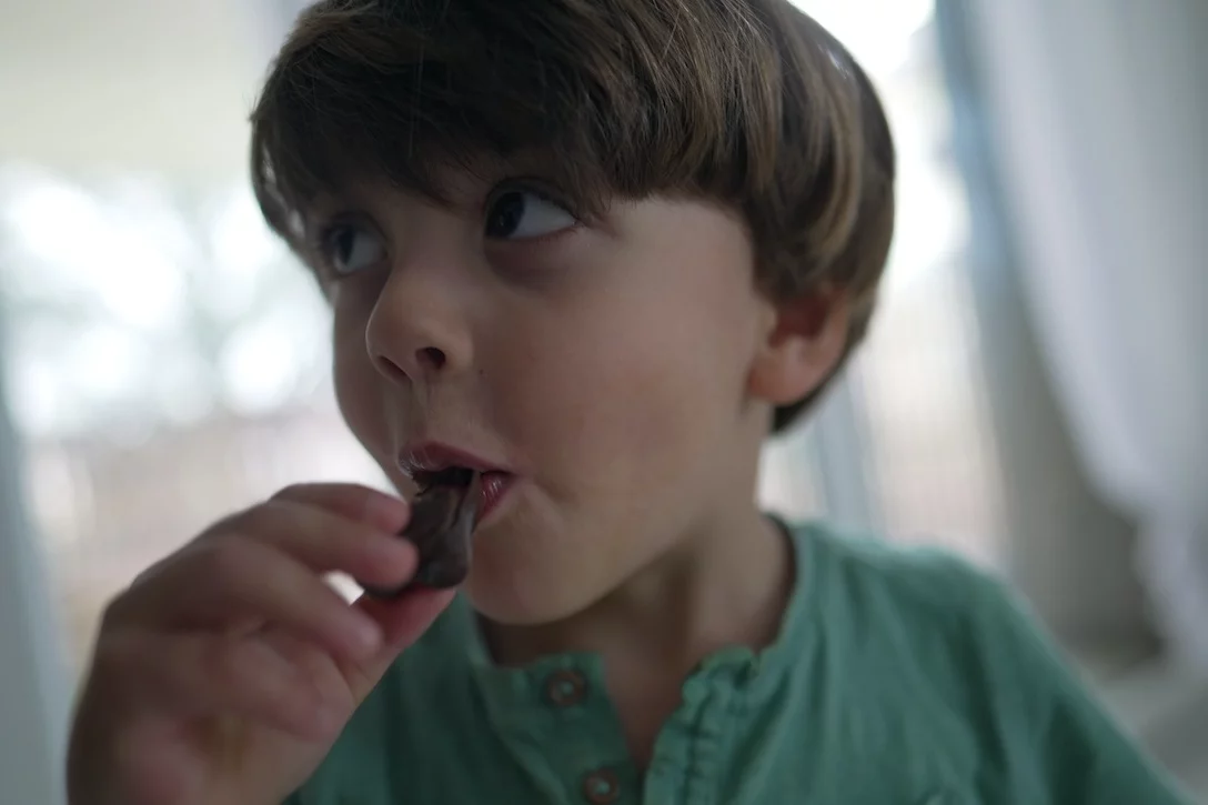 Dzień chłopaka w szkole czekoladą płynący Chłopiec je czekoladę