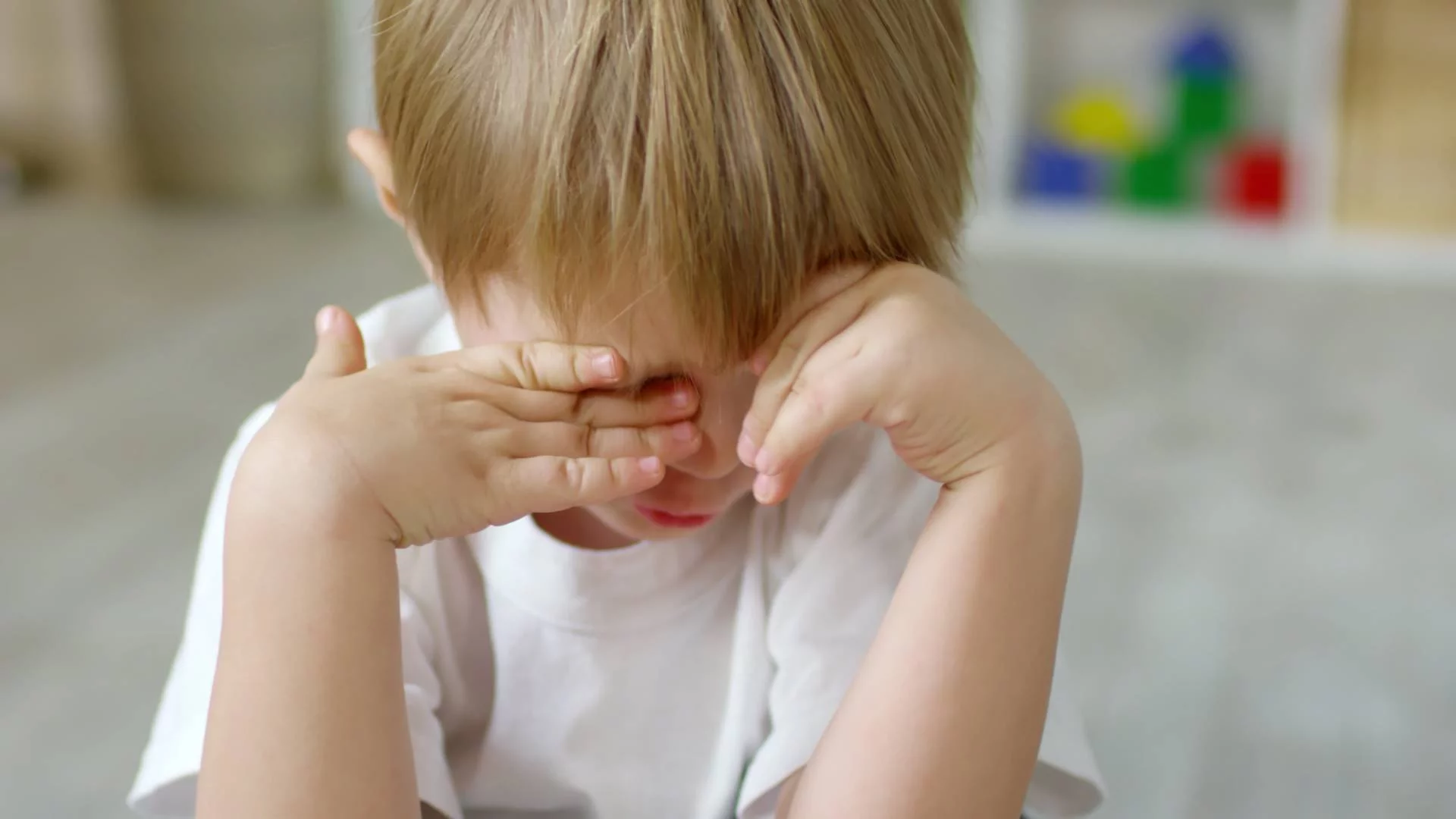 smutny chłopiec chowa twarz w dłoniach w przedszkolu smutny chłopiec chowa twarz w dłoniach w przedszkolu