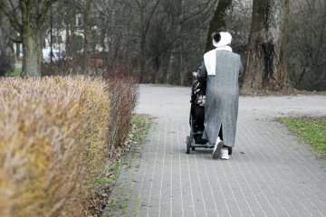 Kobieta idzie z dzieckiem w wózku.