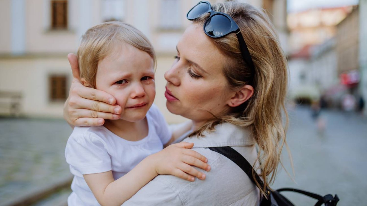 Mama pocieszająca płaczącą córkę w wieku przedszkolnym.