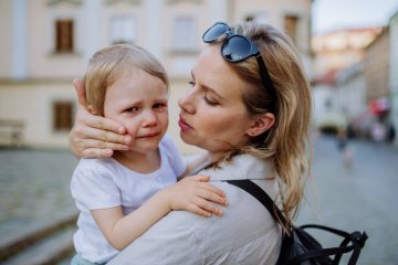 Mama pocieszająca płaczącą córkę w wieku przedszkolnym.