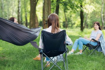 Nastolatka rozmawia z rodzicami podczas pikniku. Nastolatka rozmawia z rodzicami podczas pikniku.
