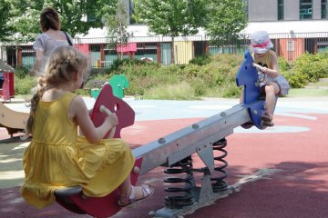 Dzieci na placu zabaw bawią się na słońcu, więc potrzebują ochrony przeciwsłonecznej.