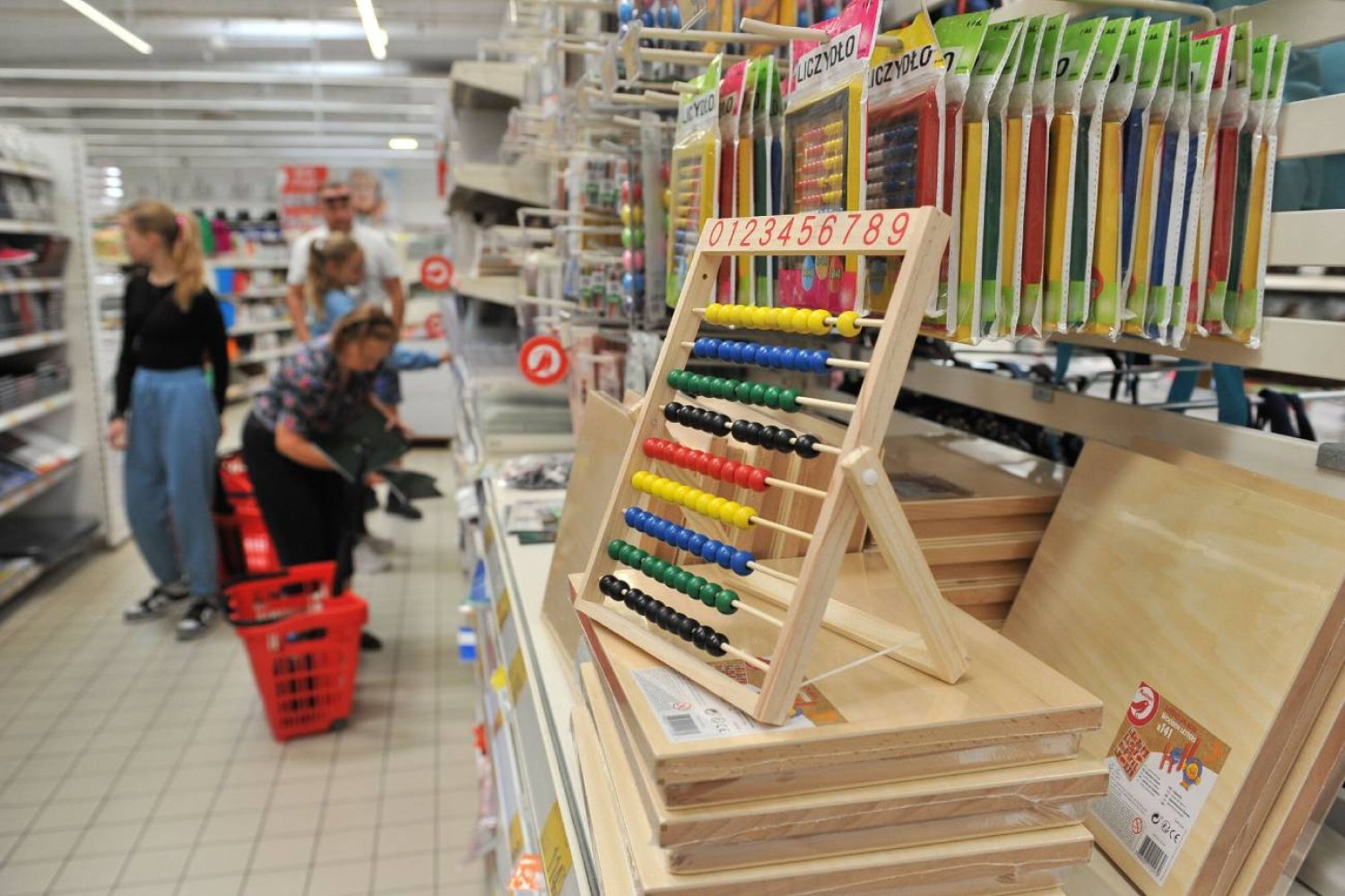 Rodzice w markecie kupują wyprawkę dla dzieci.