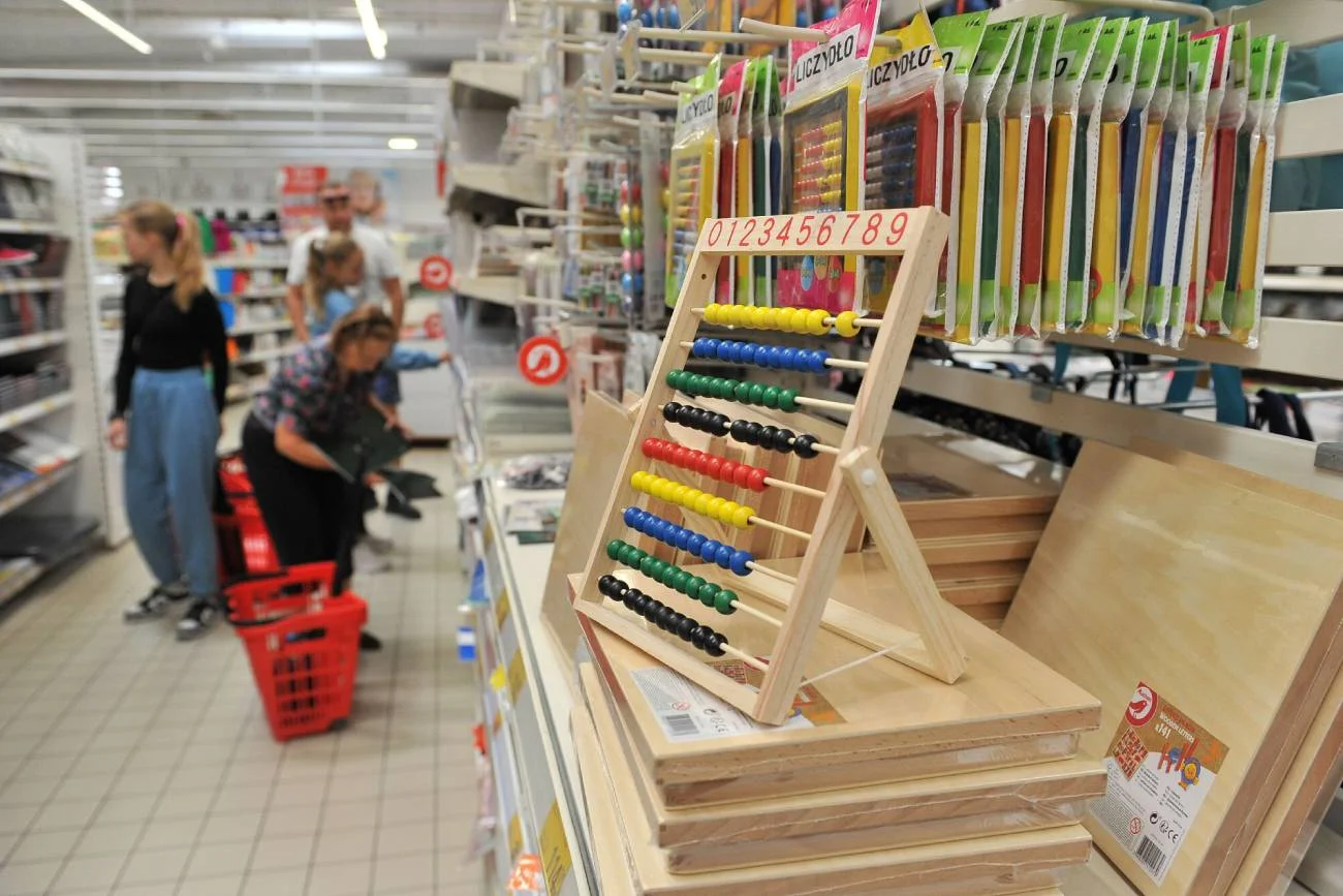 Rodzice w markecie kupują wyprawkę dla dzieci.