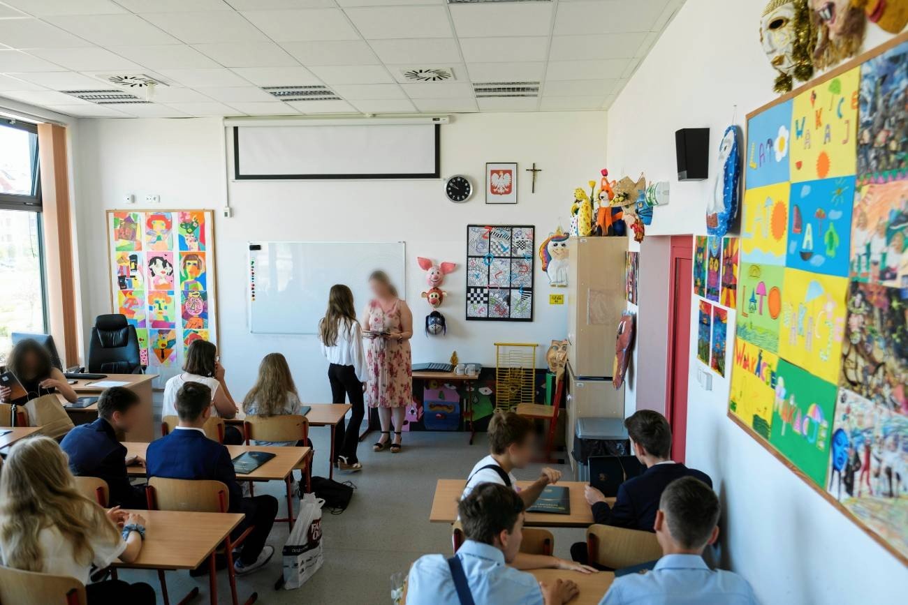 nauczycielka wręcza uczniom w klasie dyplomy