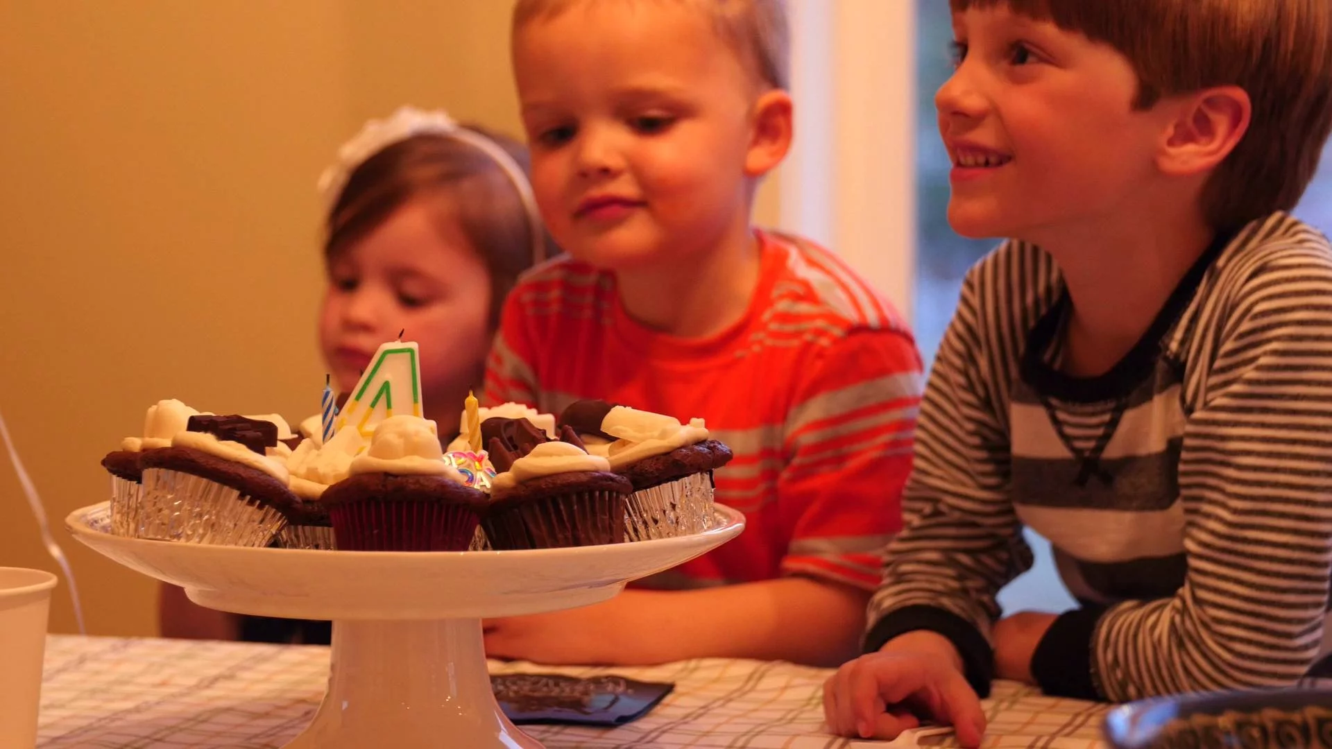 dzieci w przedszkolu świętują urodziny kolegi babeczkami