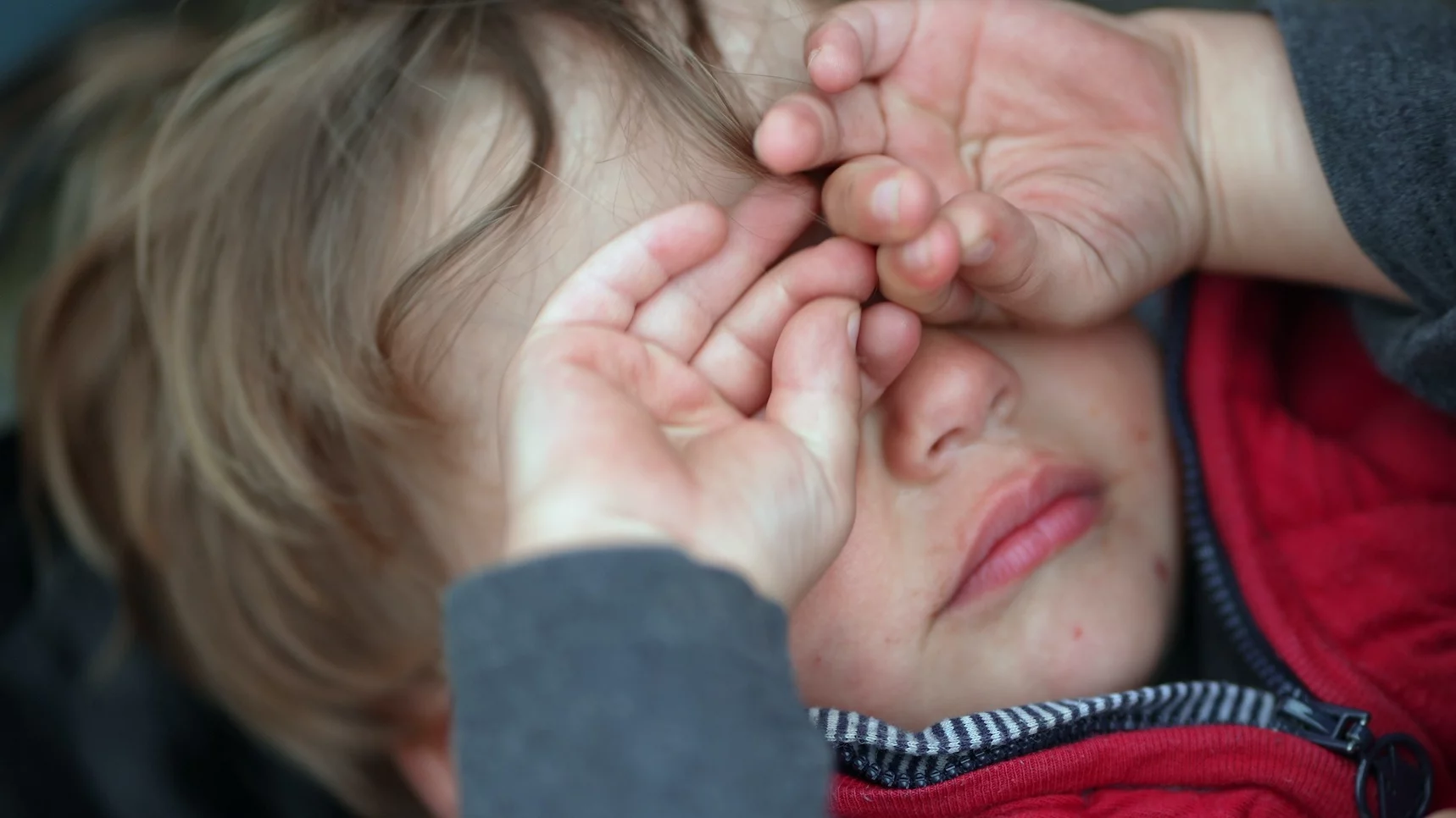 Na zdjęciu mały chłopczyk płacze i zakrywa sobie twarz