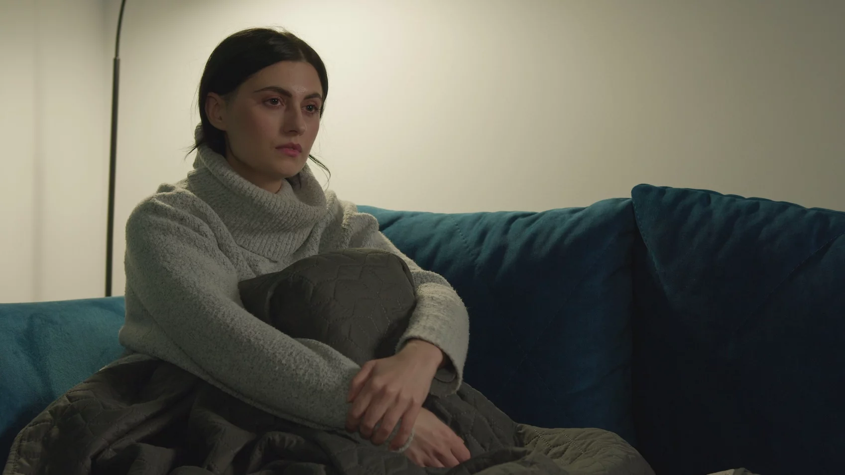 Smutna kobieta siedzi na kanapie