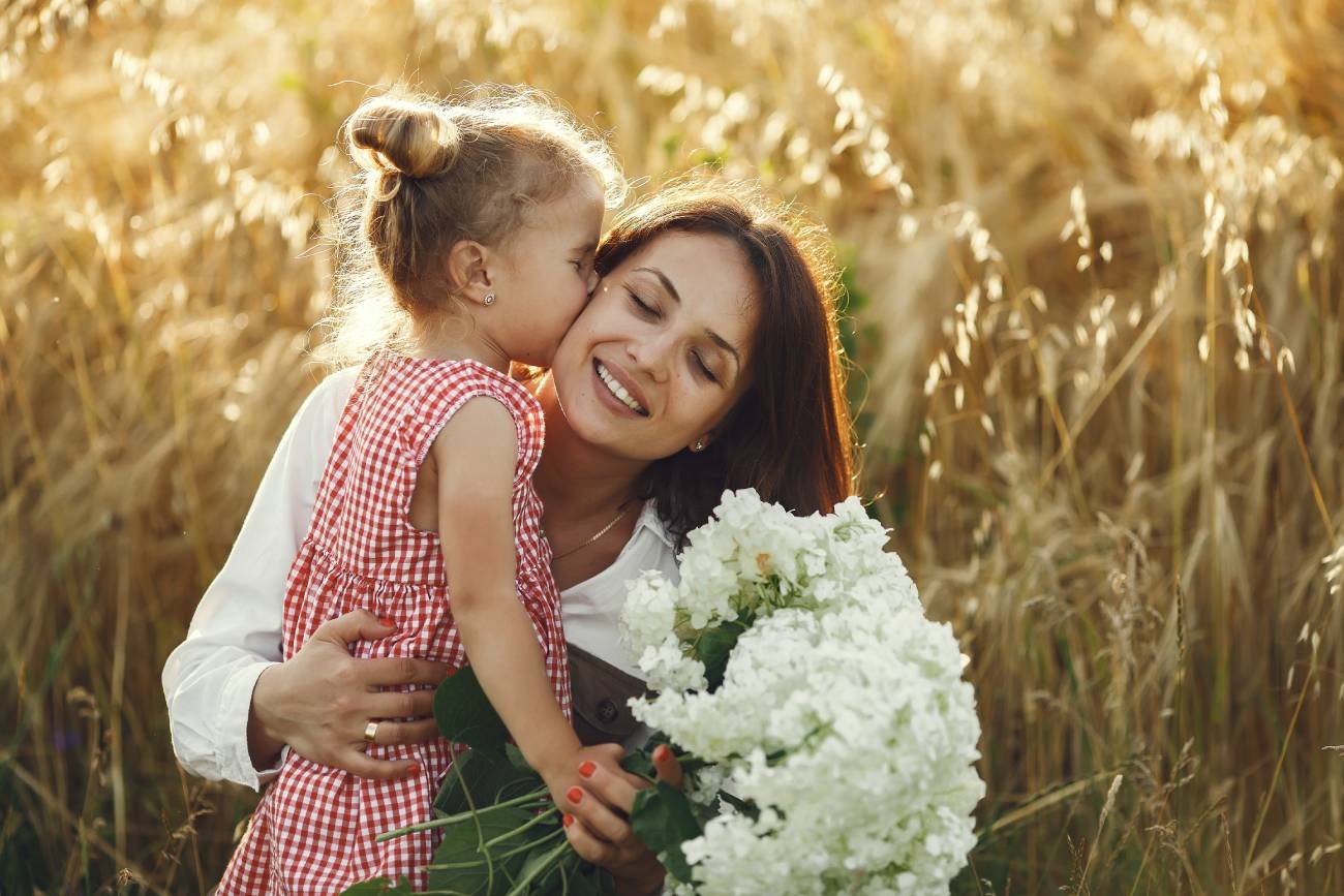 Dziewczynka wręcza mamie kwiaty z okazji Dzień Matki 2024.