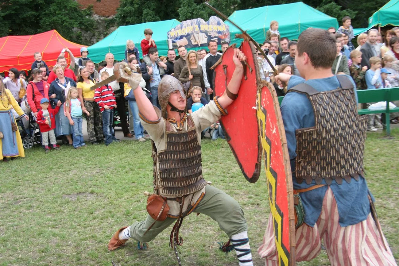 Rodzice i dzieci oglądają pokaz pojedynku rycerzy