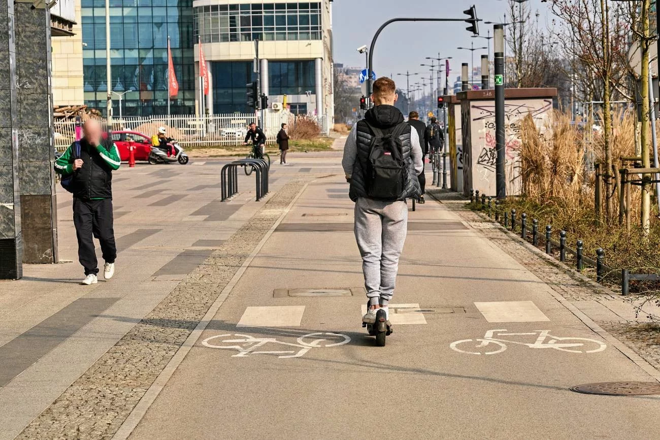 młody chłopak na hulajnodze elektrycznej jedzie przez miasto młody chłopak na hulajnodze elektrycznej jedzie przez miasto