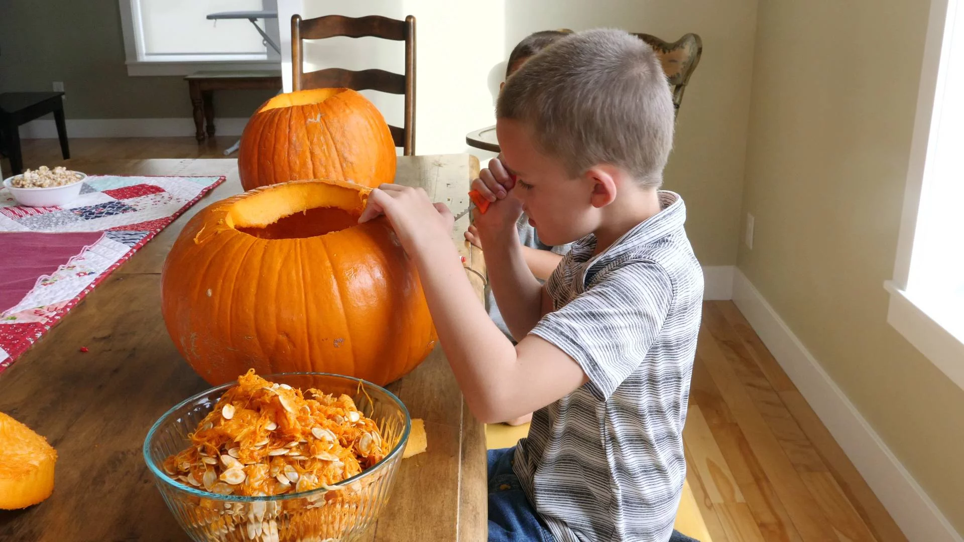 dzieci wydrążają w domu dynię na przedszkolny konkurs