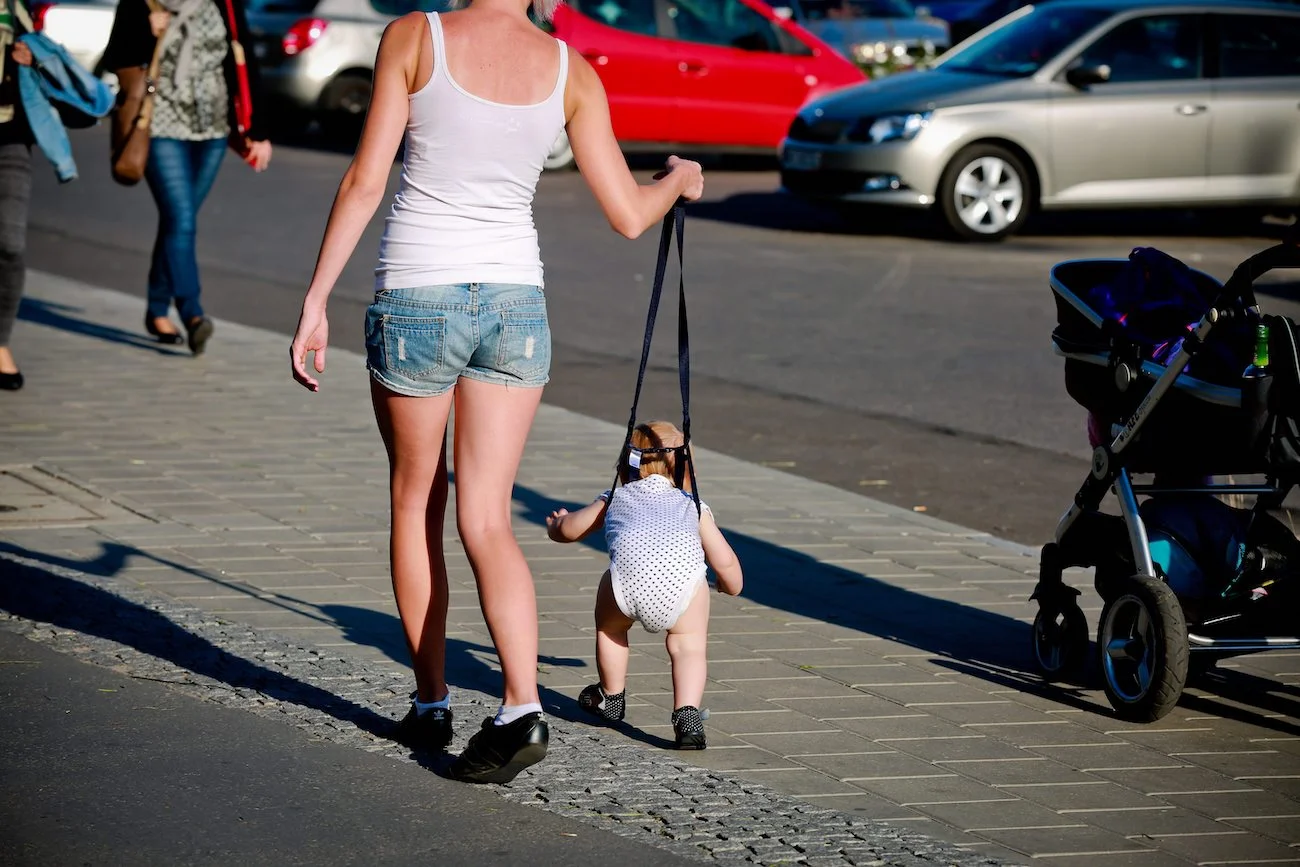 mama prowadzi dziecko na smyczy w Łodzi