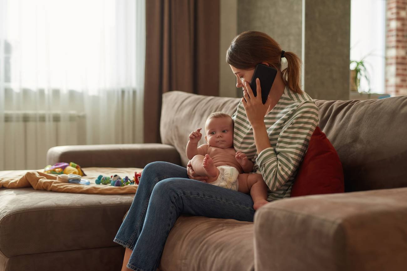 Młoda mama odbiera telefon z banku od oszusta.