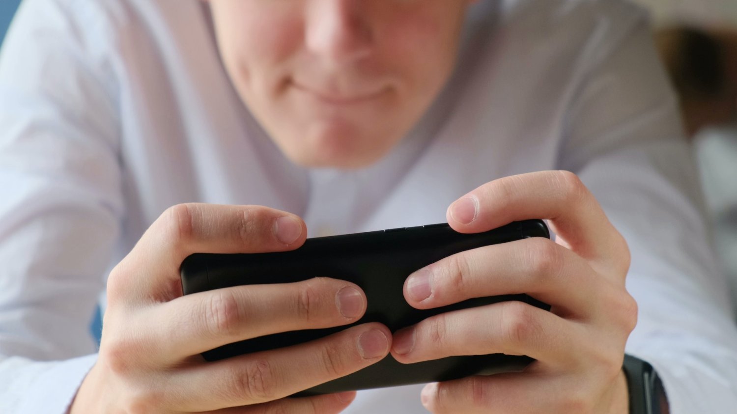 Na zdjęciu nastolatek gra na telefonie