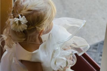 Mała dziewczynka w białej sukience na ślubie.