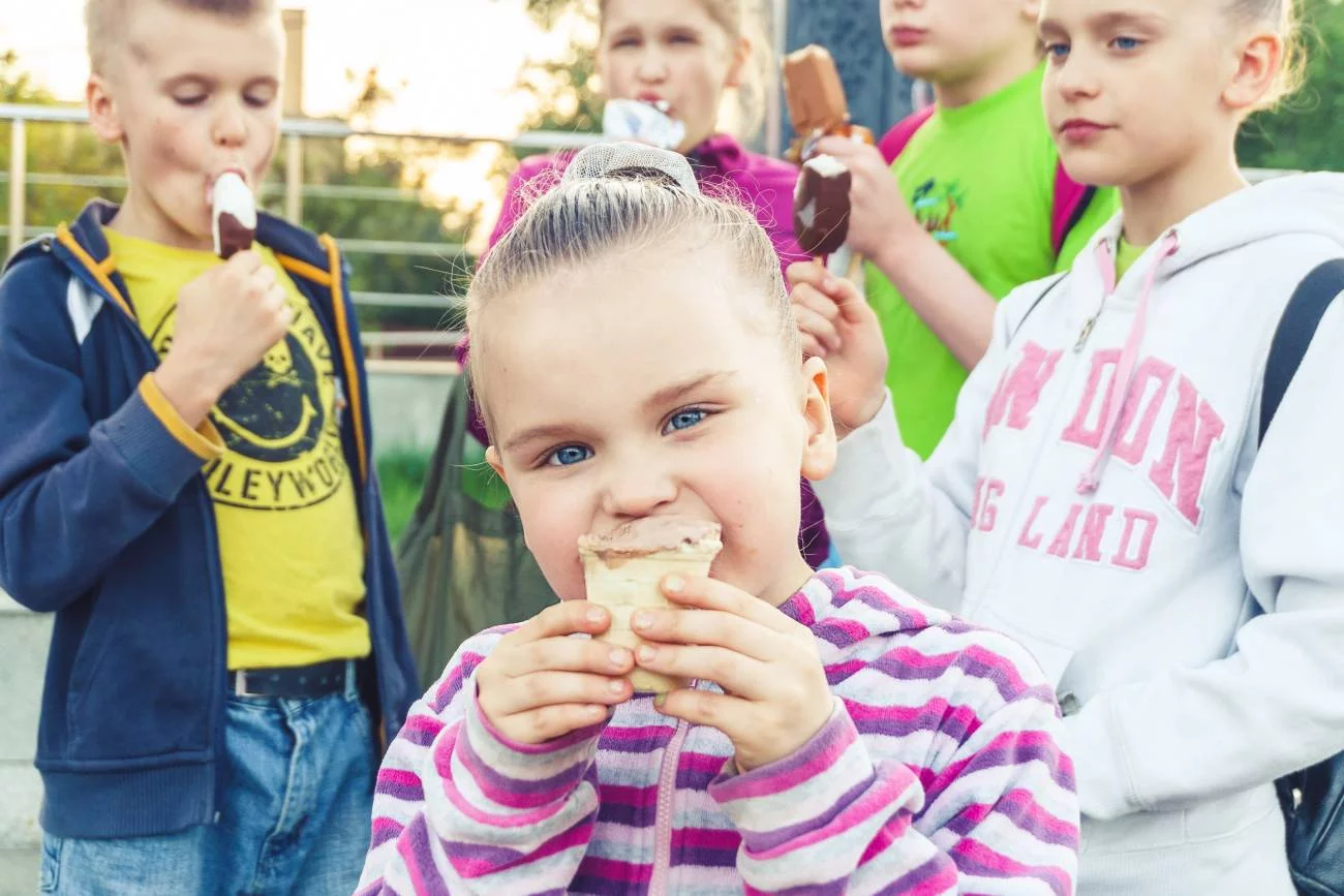Dzieci jedzą lody.
