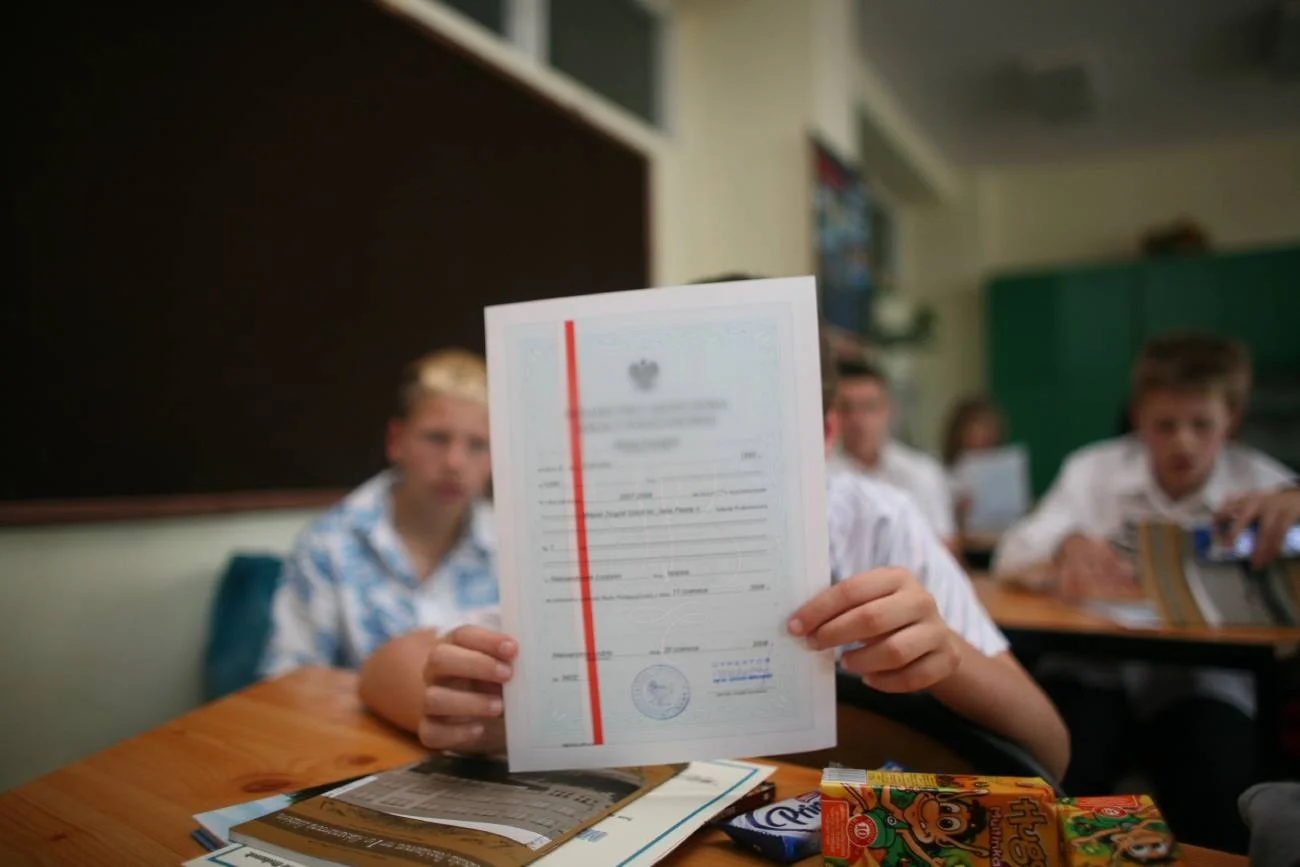 uczeń podczas zakończenia roku szkolnego ze świadectwem