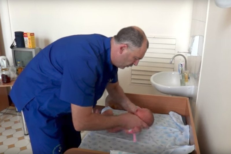 Rosyjski lekarz bada noworodka.